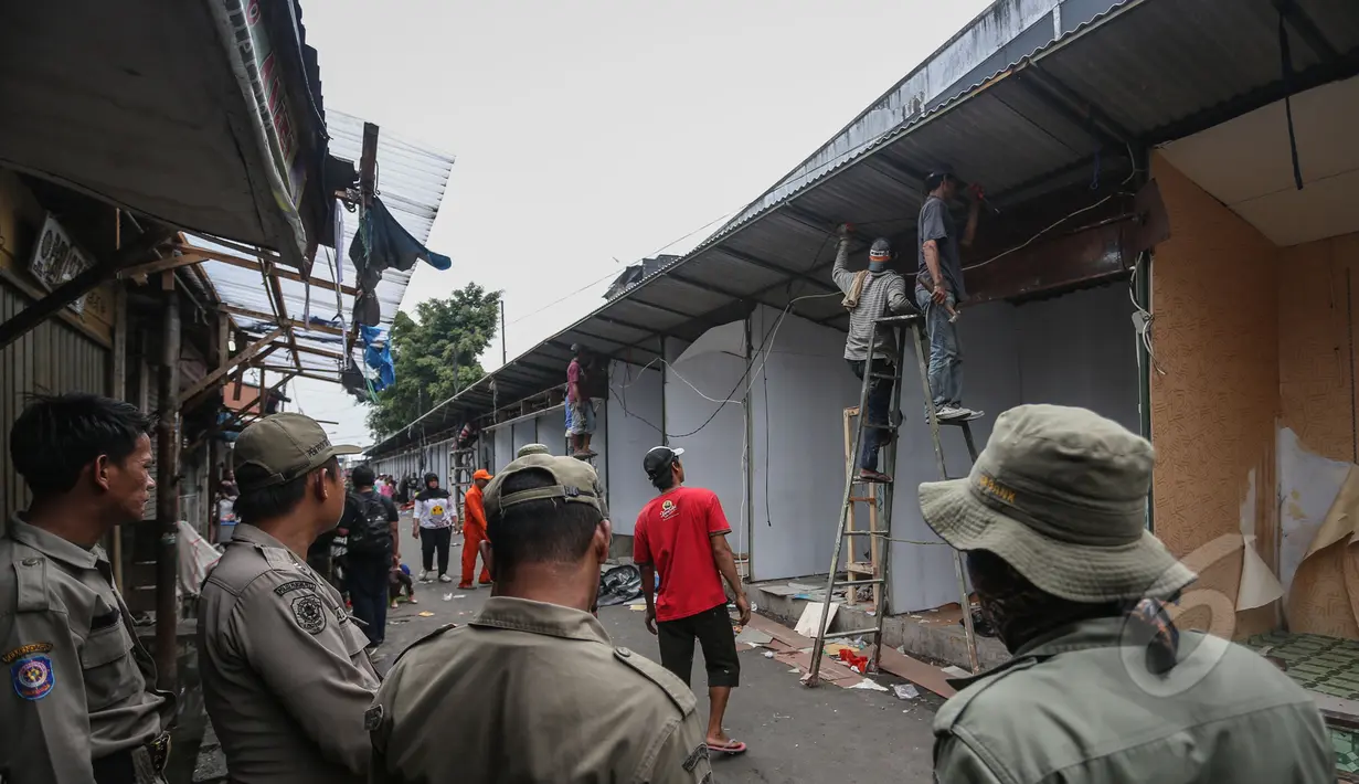 Petugas Satpol PP melihat pembongkaran kios di sepanjang Jalan Jatibaru X, Tanah Abang, Jakarta, Minggu (3/5/2015). Pembongkaran dilakukan karena kios tersebut menutupi saluran air sehingga menyebabkan saluran air mampet. (Liputan6.com/Faizal Fanani)
