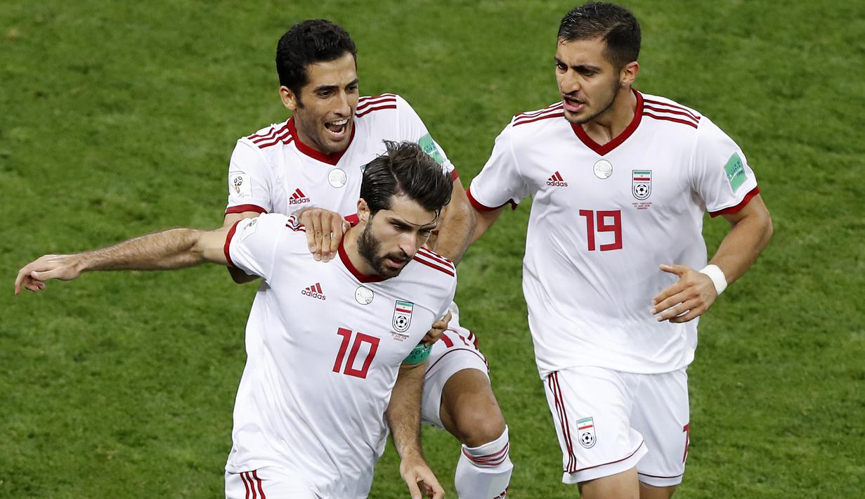 Para pemain Iran merayakan gol Karim Ansarifard (bawah) ke gawang Portugal pada laga grup B Piala Dunia 2018 di Mordovia Arena, Saransk, Rusia, (25/6/2018). Portugal dan Iran bermain imbang 1-1. (AP/Darko Bandic)