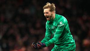 Kiper Liverpool, Caoimhin Kelleher melakukan selebrasi setelah melakukan penyelamatan pada laga final Carabao Cup 2023/2024 melawan Chelsea di Stadion Wembley, Inggris, Minggu (25/02/2024). Pertandingan dimenangkan The Reds melalui gol semata wayang Virgil Van Dijk. (AFP/Adrian Dennis)