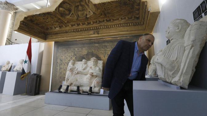 Direktur Purbakala dan Museum Suriah Mohamed Nazir Awad memeriksa artefak yang dipulihkan dari kota kuno Palmyra di Museum Nasional Damaskus, Suriah, 10 Februari 2021. Suriah memiliki enam situs warisan dunia UNESCO dan semuanya mengalami kerusakan dalam perang 10 tahun. (LOUAI BESHARA/AFP)