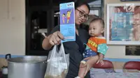 Seorang ibu menunjukkan makanan tambahan yang didapat usai mengikuti pemeriksaan rutin kesehatan bayi di Posyandu Ria Balita, Cipinang, Jakarta, Selasa (16/7/2019). Presiden Joko Widodo fokus pada kesehatan ibu hamil dan anak. (merdeka.com/Iqbal Nugroho)