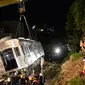 Petugas dibantu alat berat mengevakuasi gerbong KRL Commuter Line jurusan Jatinegara - Bogor di kawasan Kebon Pedes, Bogor, Jabar Minggu (10/3). Proses evakuasi menggunakan crane yang didatangkan dari Bandung. (Liputan6.com/Immanuel Antonius) 