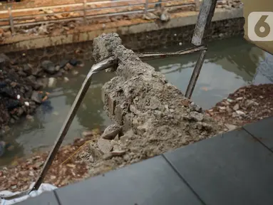 Alat berat mengeruk beton turap saluran air yang longsor di kawasan Jagakarsa, Jakarta, Kamis (17/9/2020). Selain karena hujan lebat, longsor diduga karena erosi tanah akibat pembuangan saluran air pencuci piring dan toilet dari warung makan di sekitar bantaran. (Liputan6.com/Immanuel Antonius)