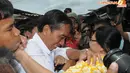 Seorang ibu tampak berusaha memeluk Jokowi namun tangan salah satu satgas berusaha menghalangi. Meski demikian, Jokowi tetap tersenyum (Liputan6.com/Herman Zakharia)
