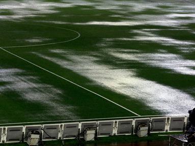 Seorang kamerawan berdiri di pinggir lapangan Stadion Monumental, Buenos Aires, Argentina, yang banjir karena guyuran hujan deras sebelum laga Kualifikasi Piala Dunia 2018 antara Argentina melawan Brasil. Jumat (13/11/2015) WIB. (Reuters/Marcos Brindicci)