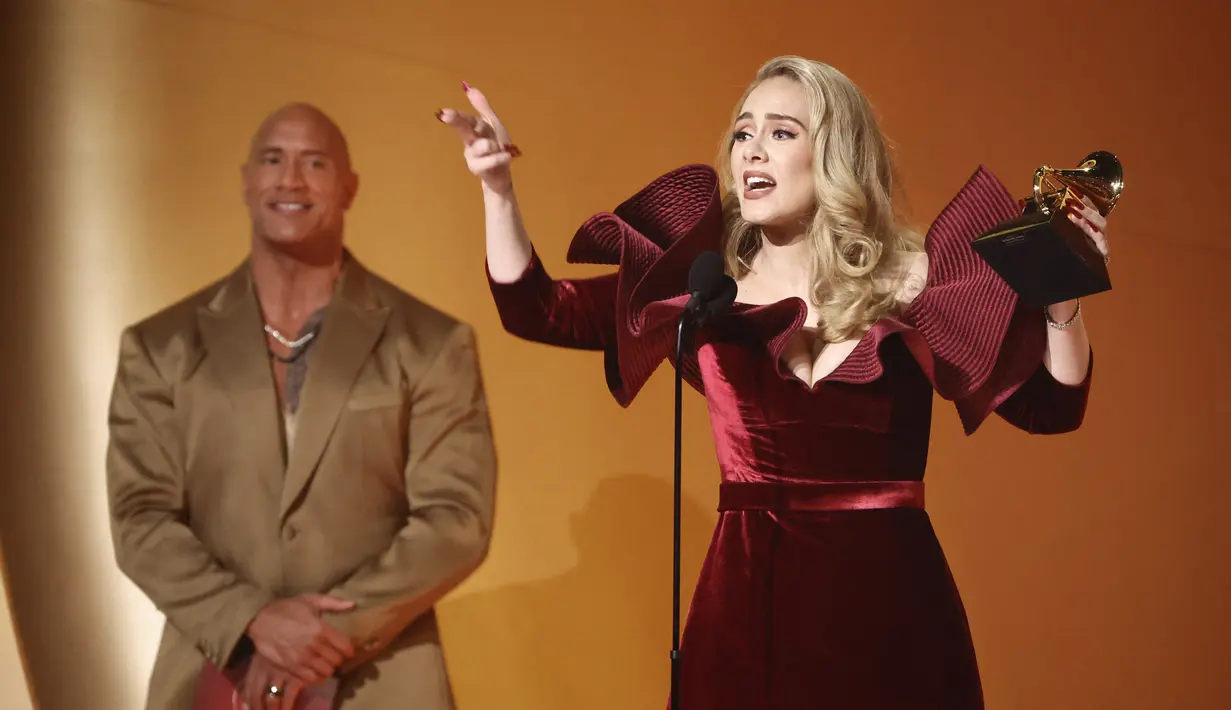 Adele saat menerima penghargaan Best Pop Solo Performance untuk lagu "Easy On Me," di atas panggung selama Grammy Awards 2023 di Crypto.com Arena di Los Angeles, California pada 5 Februari 2023. Berjumpa dengan Dwayne Johnson alias The Rock , Adele benar-benar sangat bahagia. (Frazer Harrison/Getty Images/AFP)