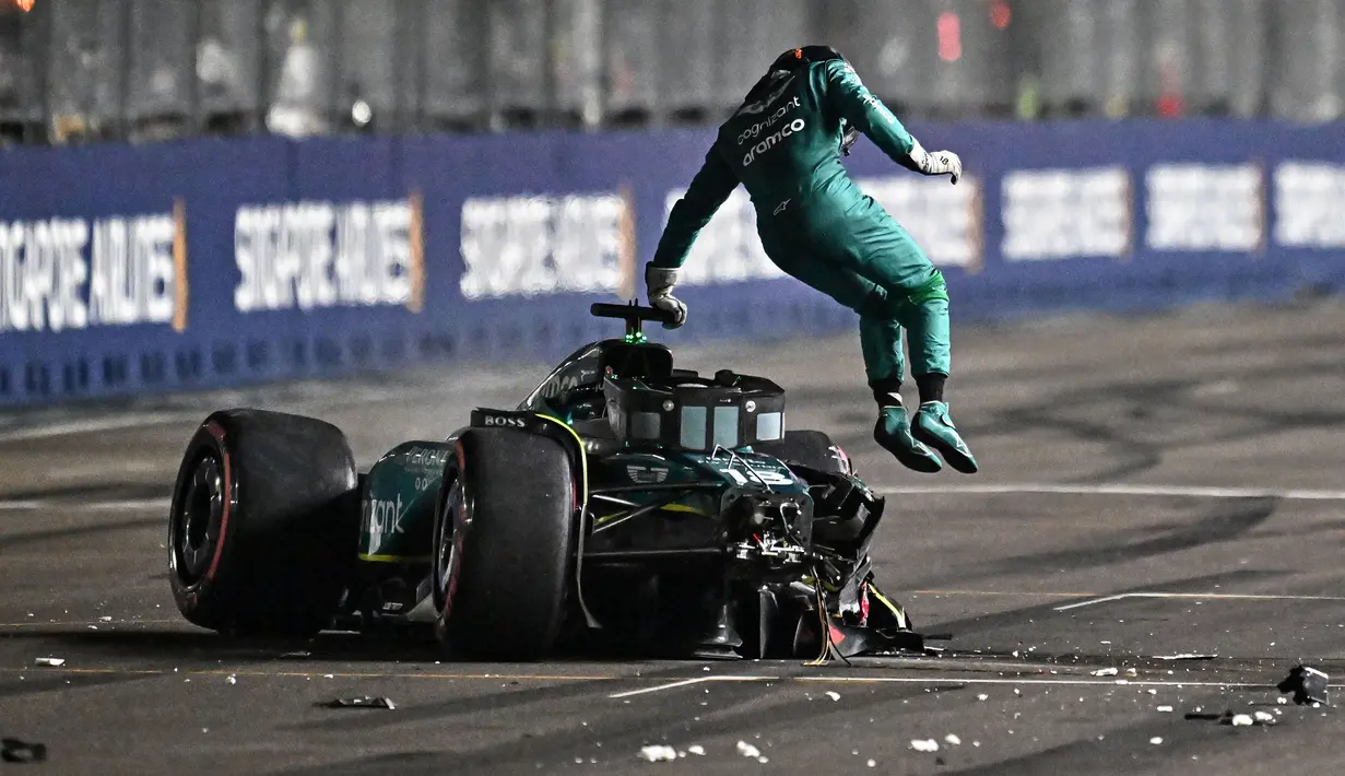 Pembalap Aston Martin, Lance Stroll melompat ke luar dari mobilnya setelah tabrakan pada sesi kualifikasi Formula 1 GP Singapura 2023 di Marina Bay Street Circuit, Singapura, 16 September 2023. (AFP/Lillian Suwanrumpha)