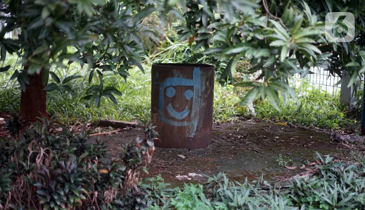 Coretan mengotori tong di Taman Martha Tiahahu yang terbengkalai di kawasan Blok M, Jakarta Selatan, Selasa (17/11/2020). Taman yang berdiri sejak 1948 tersebut kini kondisinya terbengkalai, dengan sampah dan rumput liar yang tumbuh hampir di seluruh sudut taman. (Liputan6.com/Immanuel Antonius)
