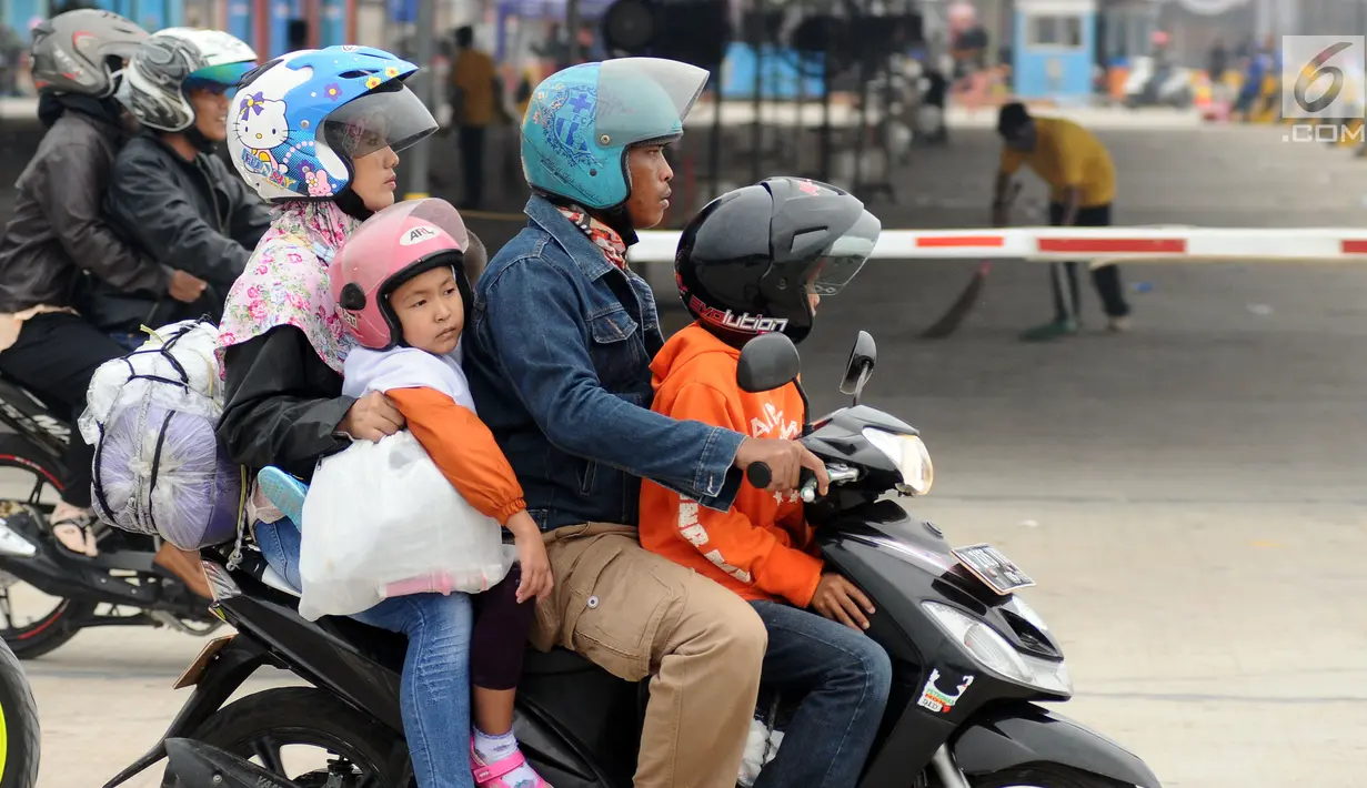 Pemudik membawa anaknya bersiap masuk kapal penyereberangan di Dermaga 6 Pelabuhan Merak, Banten, Kamis (22/6). Meski sudah dihimbau oleh pihak berwenang, namun masih banyak pemudik bermotor yang membawa anak. (Liputan6.com/Helmi Fithriansyah)