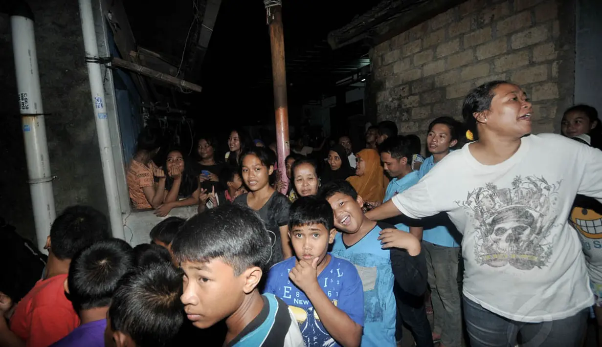Puluhan warga terlihat mengerumuni rumah terduga teroris usai penggerebekan yang dilakukan Densus 88 Anti Teror Mabes Polri, Jakarta, Selasa (24/6/14). (Liputan6.com/Johan Tallo)