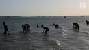 Warga mencari kerang laut di pesisir pantai Pulau Pasir, Lombok Timur, Sabtu (3/8/2019). Mereka mulai menangkap kerang ketika Pulau Pasir yang membentang laut akan tampak ketika air laut surut. (Liputan6.com/Fery Pradolo)