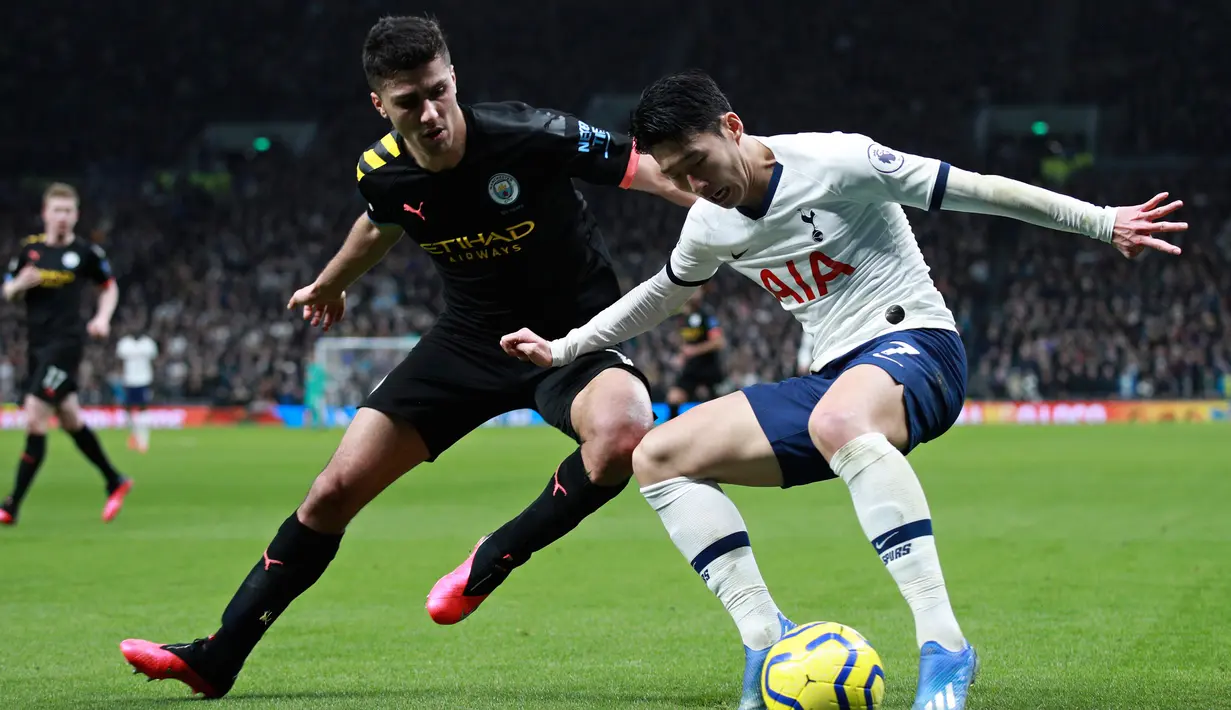 Pemain Tottenham Hotspur Son Heung-min (kanan) mencoba melewati pemain Manchester City Rodrigo pada pertandingan Liga Inggris di  Stadion Tottenham Hotspur, London, Inggris, Minggu (2/2/2020). Tottenham Hotspur mengalahkan Manchester City 2-0. (AP Photo/Ian Walton)