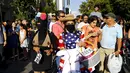 Seorang aktivis mengunakan pakaian bendera AS seperti peteani berunjuk rasa terhadap kesepakatan perdagangan TPP, Santiago, Chili, (4/2). Tujuan TPP adalah mendorong liberalisasi negara-negara di kawasan Asia-Pasifik. (REUTERS/Ivan Alvarado)