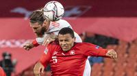 Bek Spanyol, Sergio Ramos, duel udara dengan pemain Swiss, Manuel Akanji, pada laga UEFA Nations League di Stadion St. Jakob-Park, Minggu (15/11/2020). Kedua tim bermain imbang 1-1. (Georgios Kefalas/Keystone via AP)