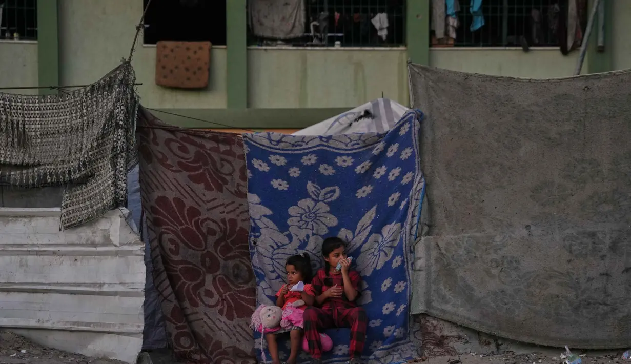 Gadis-gadis Palestina duduk di depan tenda keluarga mereka yang didirikan di sebuah area di Khan Younis, Jalur Gaza selatan, Jumat, 31 Oktober 2025. Organisasi bantuan, seperti yang didukung oleh Program Pangan Dunia (WFP), berupaya menyediakan makanan, namun menghadapi tantangan besar dalam distribusi dan pasokan yang tidak mencukupi target harian. (AP Photo/Abdel Kareem Hana)