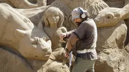 Seniman asal Ukraina Andrey Vazhinsky saat membuat sebuah patung dari pasir yang menyerupai para pemain film The Jungle Book di Kazakhstan , 15 April 2016. Kebanyakan patung yang dibuat terinspirasi dari film - film Hollywood. (REUTERS / Shamil Zhumatov)