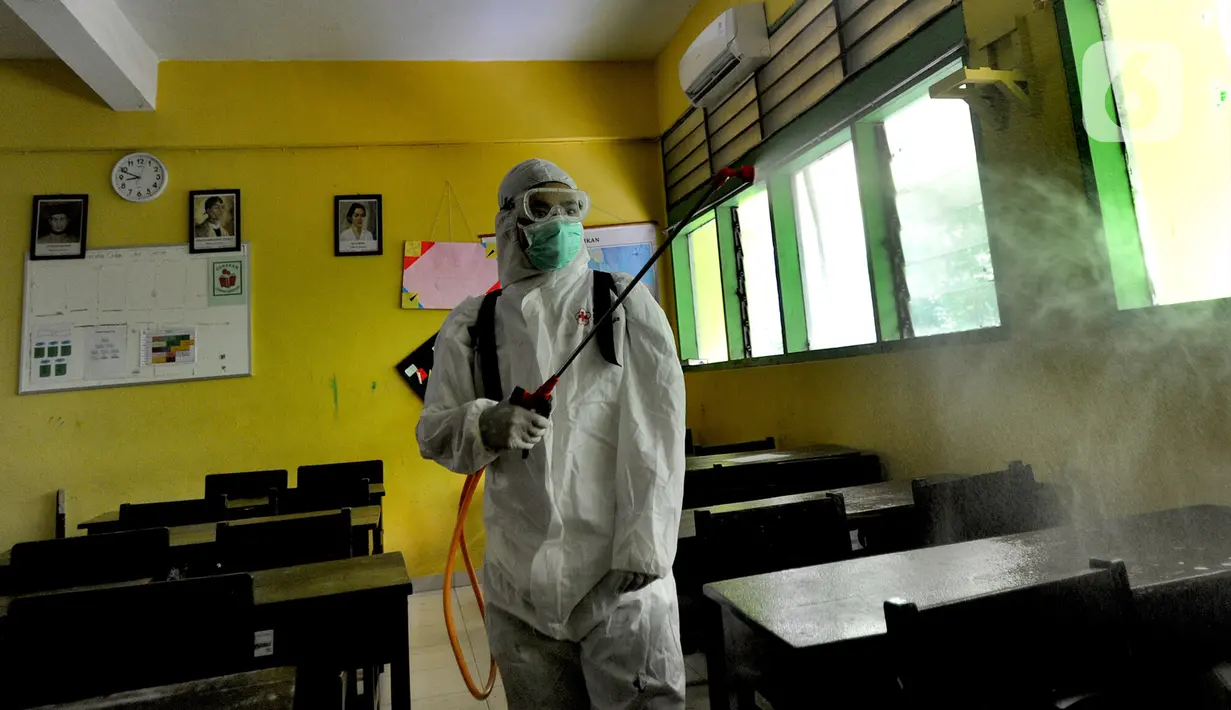 Petugas Palang Merah Indonesia (PMI) melakukan penyemprotan disinfektan di SMPN 216 Jakarta, Senin (16/3/2020). Mulai hari ini, aktivitas sekolah di sejumlah wilayah Indonesia diliburkan untuk mengantisipasi penyebaran virus corona COVID-19. (merdeka.com/Arie Basuki)