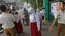 Sejumlah murid  memasuki sekolah  SD Negeri 6, Bekasi, Jawa Barat, Selasa (4/8/2020). Pemerintah setempat memberikan izin kepada enam sekolah untuk melakukan uji coba pembelajaran tatap muka selama satu bulan. (Liputan6.com/Herman Zakharia)