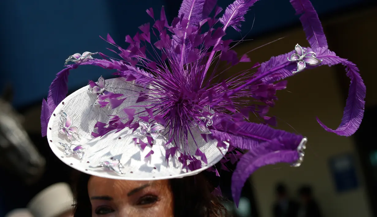 Seorang wanita mengenakan hiasan kepala saat ia tiba untuk hari pertama pertemuan pacuan kuda Royal Ascot di Ascot, Inggris (20/6). Mereka tampil gaya saat menyaksikan kompetisi balap kuda ini. (AP Photo/Alastair Grant)