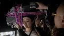 Seorang model saat dipakaikan topi di belakang panggung sebelum memamerkan koleksi oleh Zhang Kejia selama China Fashion Week di Beijing (26/3). (AFP Photo/Nicolas Asfouri)