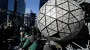 Pekerja menyelesaikan pemasangan kristal berbentuk segitiga pada bola kristal di atas One Times Square, New York, Amerika Serikat, Rabu (27/12). Nantinya, bola kristal tersebut akan diluncurkan ke bawah pada malam tahun baru. (AP/Seth Wenig)