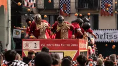 Peserta dan pasukan penjaga saling melemparkan jeruk sebagai bagian dari tradisi "perang jeruk" selama Karnaval Ivrea di Turin, Italia, Minggu (3/3). Festival ini biasa dilaksanakan di bulan Februari setiap tahunnya selama tiga hari (MARCO BERTORELLO/AFP)