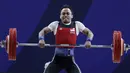 Lifter Suratman melakukan angkatan saat SEA Games 2019 cabang angkat besi nomor 55 kg di Stadion Rizal Memorial, Manila, Minggu (1/12). Dirinya meraih perak dengan total angkatan 250 kg. (Bola.com/M Iqbal Ichsan)