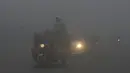 Sejumlah kendaraan melintas saat kabut asap tebal menyelimuti Lahore, Pakistan (3/1). Polusi udara telah menyebar akibat asap kendaraan, situs bangunan dan petani yang membakar tanaman di daerah di luar ibukota India. (AFP Photo/Arif Ali)