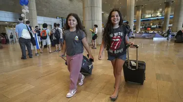 Dua gadis yang tiba dari negara kepulauan Seychelles di Samudra Hindia yang melakukan pemberhentian darurat di Arab Saudi bereaksi saat mendarat di Bandara Ben Gurion di Lod, dekat Tel Aviv, Israel, Selasa (29/8/2023). (AP Photo/Tsafrir Abayov)