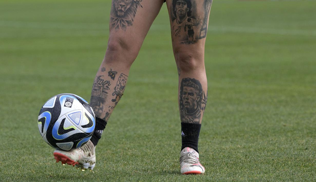 <p>Tato bintang Portugal, Cristiano Ronaldo (kanan bawah) dan legenda Argentina, Diego Maradona (kanan atas) milik pemian Timnas Wanita Argentina, Yamila Rodriguez saat sesi latihan menjelang Piala Dunia Wanita 2023 di Ezeiza, Buenos Aires, Argentina 6 Juli 2023. (AFP/Juan Mabromata)</p>