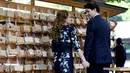  Perdana Menteri Kanada Justin Trudeau bersama istrinya Sophie Gregoire Trudeau saling pegangan tangan saat mereka mengantungkan 'Ema' atau sebuah harapan yang mereka tulis di sebuah kayu di Kuil Meiji di Tokyo, Jepang (24/5).  (REUTERS/Issei Kato)