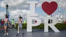 Turis berjalan melalui area dok setelah keluar dari kapal pesiar Mardi Gras Carnival yang berlabuh di Teluk San Juan, Puerto Rico, Selasa (3/8/2021). Mardi Gras Carnival menjadi kapal pesiar pertama yang mengunjungi wilayah AS sejak pandemi COVID-19. (AP Photo/Carlos Giusti)