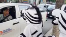 Warga berpakaian seperti zebra berbincang dengan pengendara mobil saat program pendidikan di jalan di La Paz, Bolivia,(5/12). Kegiatan ini untuk meningkatkan kesadaran masyarakat tentang keselamatan di jalan. (REUTERS/David Mercado)