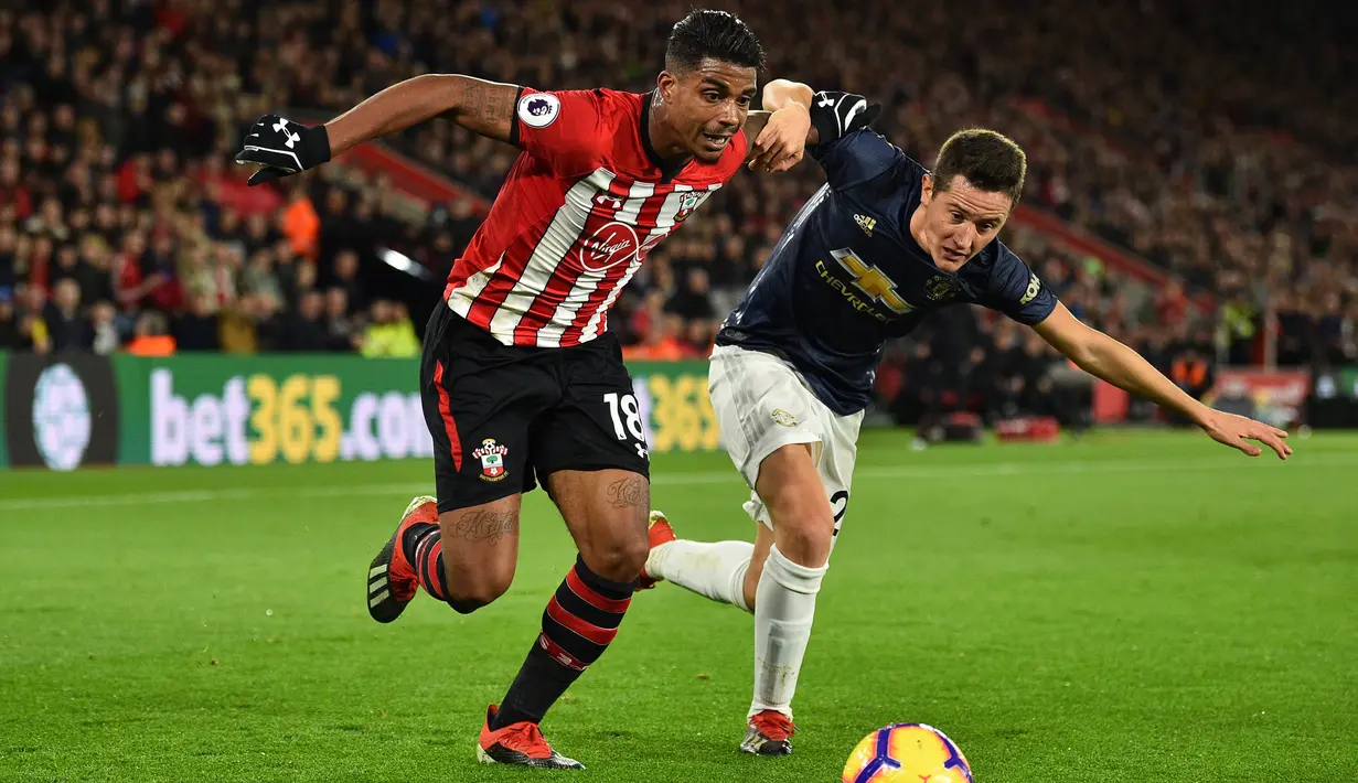 Gelandang Southampton, Mario Lemina, berebut bola dengan gelandang Manchester United, Ander Herrera, pada laga Premier League di Stadion St Mary, Southampton, Sabtu (1/12). Kedua klub bermain imbang 2-2. (AFP/Glyn Kirk)