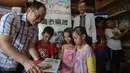 Direktur Pelaksana TIKI Rocky Nagoya memberikan buku kepada anak-anak di Yayasan 1001 Buku, Jakarta, Senin (8/5). Memperingati Hari Pendidikan Nasional pada 2 Mei, TIKI mendonasikan dana untuk Yayasan 1001 Buku. (Liputan6.com/Faizal Fanani)