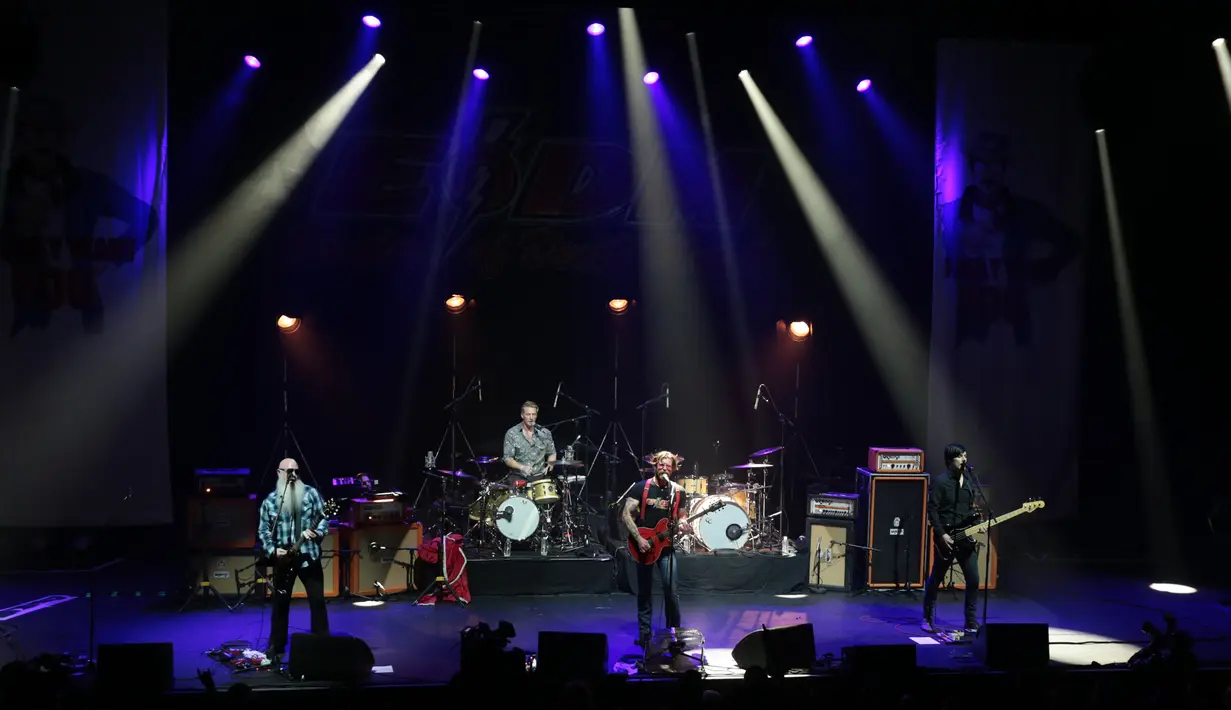 Grup rock Eagles of Death Metal tampil di atas panggung gedung teater Olympia, Paris, Selasa (16/2). Grup rock asal California itu menggelar konser di hadapan ratusan penggemar yang selamat dari serangan teror pada November lalu. (AFP PHOTO/Joel SAGET)