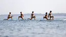Sejumlah wanita mengenakan bikini saat melakukan gerakan yoga dengan papan seluncur di Laut Adriatic, Kroasia, Kamis (6/8/2015). (REUTERS/Pawel Kopczynski)