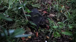 Sebuah topi tergeletak di tanah dekat  kuburan massal rahasia yang ditemukan di Arbolillo, negara bagian Veracruz, Meksiko, Jumat (7/9). Dari jumlahnya, temuan kuburan massal di Veracruz ini merupakan salah satu yang terbesar di Meksiko (AP/Felix Marquez)