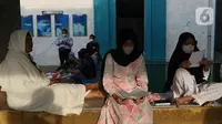 Umat Islam membaca Al-Quran sambil menunggu waktu berbuka puasa di halaman Masjid Raya Jakarta Islamic Center, Jakarta Utara, Senin (18/4/2022). Acara ngabuburit sambil khataman Al-Quran ini merupakan rangkaian acara menyambut 17 Ramadhan atau malam Nuzulul Quran. (Liputan6.com/Herman Zakharia)