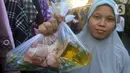 Seorang warga menunjukkan bungkusan plastik berisi bahan makanan. (merdeka.com/Arie Basuki)