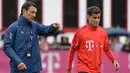 Pemain Bayern Munchen, Philippe Coutinho, mendengarkan instruksi Niko Kovac saat latihan perdananya di Munchen, Selasa (20/8). Bintang Brasil ini didatangkan dari Barcelona. (AFP/Christof Stache)