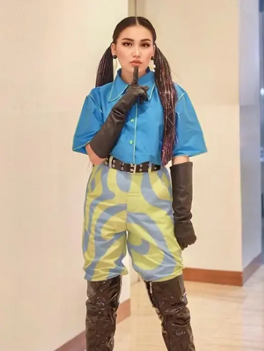 Meski warna outfitnya tak terlihat matching, namun pelantun lagu "Sambal Balado" ini tetap sukses tampilkan gaya uniknya. Tampil dengan gaya rambut kepang, penampilannya bak ABG. (Liputan6.com/IG/@ayutingting92)