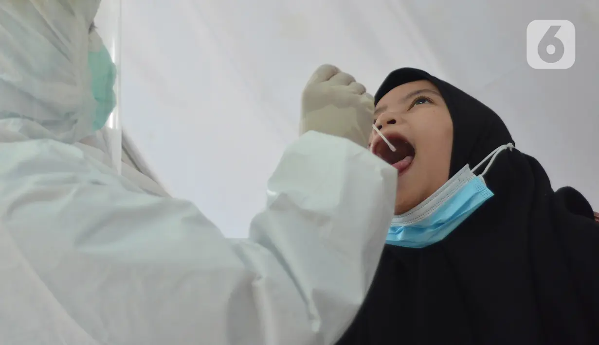 Seorang perempuan mengikuti tes swab PCR massal di Kantor Kecamatan Pancoran Mas, Depok, Selasa (5/1/2021). Puskesmas Pancoran Mas melakukan tes Swab PCR kepada warga yang pernah memiliki riwayat kontak erat dengan pasien terkonfirmasi positif Covid-19. (merdeka.com/Arie Basuki)