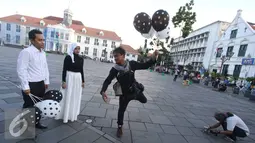 Fotografer memeragakan gaya untuk foto pranikah di kawasan Kota Tua, Jakarta, Kamis (29/9). Gubernur DKI Jakarta Basuki Tjahaja Purnama memastikan aktivitas foto pranikah di Kota Tua tidak dipungut biaya. (Liputan6.com/Immanuel Antonius)