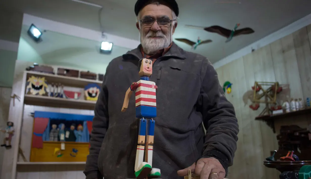 Francisco Jose Munoz (65) menunjukkan patung kayu buatannya di bengkelnya "Arbole" di Albolote dekat Granada, Spanyol (11/12). (AFP Photo/Jorge Guerrero)