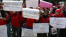Puluhan mantan karyawan 7-Eleven (Sevel) membawa poster saat melakukan aksi di Jakarta, Rabu (22/2). Puluhan eks karyawan mengenakan seragam merah membawa sejumlah spanduk  dan poster. (Liputan6.com/Angga Yuniar)