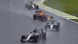 Hujan deras yang mengguyur Sirkuit Interlagos, Brasil, membuat awal balapan menjadi tidak menarik karena pebalap tak boleh melakukan manuver untuk menyalip rivalnya. (AFP/Miguel Schincariol)