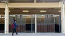 Pewarta melintas di depan istal di kawasan Jakarta International Equestrian Park Pulomas, Jakarta, Kamis (2/8). JIEPP akan menjadi venue tiga cabang equestrian Asian Games 2018. (Liputan6.com/Helmi Fithriansyah)