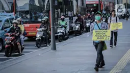 Koalisi Pejalan Kaki berjalan saat menggelar aksi di Trotoar Thamrin, Jakarta, Rabu (22/1/2020). Aksi tersebut dalam rangka memperingati Hari Pejalan Kaki Nasional pada 22  Januari, serta  mengajak pengendara untuk tertib lalu lintas serta menghormati hak pejalan kaki. (Liputan6.com/Faizal Fanani)