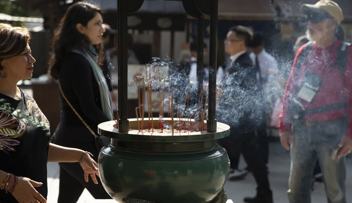 Wisatawan melewati pembakaran dupa di kuil Budha Kiyomizu-dera di Kyoto, Jepang (31/10/2019). Kuil ini adalah situs Warisan Dunia UNESCO dan salah satu tempat wisata paling terkenal di Kyoto. (AP Photo / Aaron Favila)